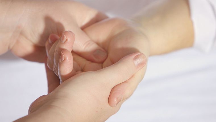 Caregiver touching patients hand